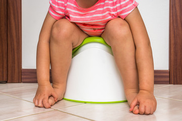 Child is sitting on baby potty - obrazy, fototapety, plakaty