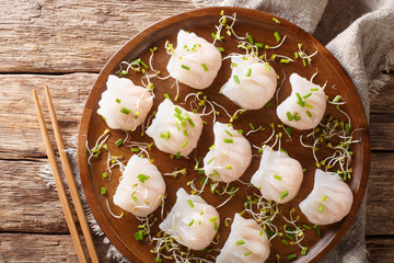 Traditional Chinese dim sum with shrimp filling served with sprouts close-up on a plate. horizontal top view