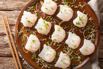 Delicious dumplings dim sum with shrimp served with sprouts close-up on a plate. horizontal top view