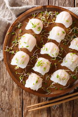 Traditional Chinese dim sum with shrimp filling served with sprouts close-up on a plate. Vertical top view