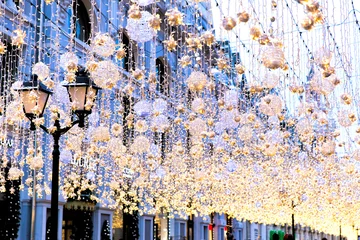 Cercles muraux Paris Guirlandes lumineuses de Noël et lampes de poche dans une rue de la ville