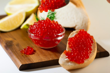 red caviar in glassware on wooden background with space for text