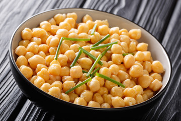 Organic snack boiled chickpeas close-up in a black bowl. horizontal