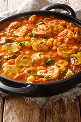 Spicy vegetarian mushroom curry with spinach and chickpeas close-up in a frying pan. vertical