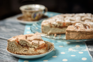 Homemade apple pie with cup of coffee on grey wooden table.