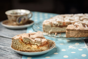 Homemade apple pie with cup of coffee on grey wooden table.