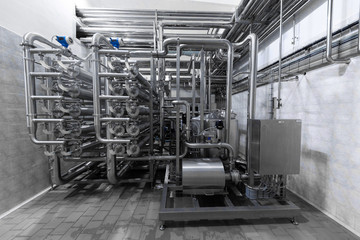 Industrial pipelines and modern equipment in cheese production interior