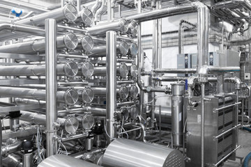 Industrial pipelines and modern equipment in cheese production interior