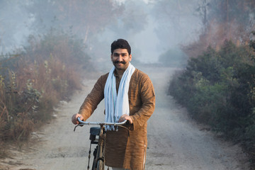Young man standing with bicycle on morning
