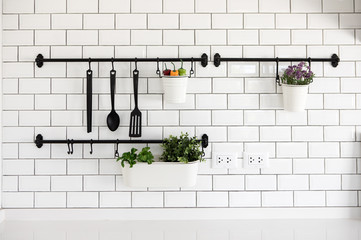 kitchen utensil hanger on white brick wall