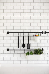 kitchen utensil hanger on white brick wall
