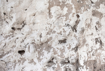 Closeup of beige porous stone textured wall with damaged paint. For background, product designs or skin