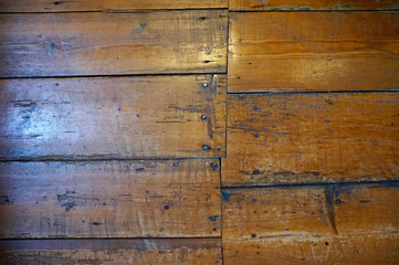 Old wood floors set in an uneven pattern, with nails showing. Some window light. Scratched and...