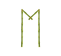 Capital letter M made of green bamboo poles on white background.