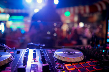 DJ Spinning, Mixing, and Scratching in a Night Club, Hands of dj tweak various track controls on dj