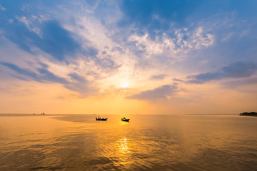 Beautiful sunrise on the beach and silhouette of fishing boat.Thailand.
