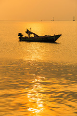 Beautiful sunrise on the beach and silhouette of fishing boat.Thailand.