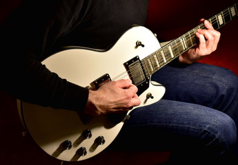 Man playing a electric guitar. Closeup, no face.