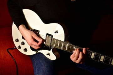 Man playing a electric guitar. Closeup, no face.