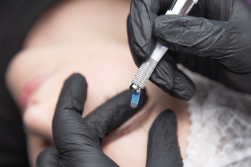 Permanent Makeup For Eyebrows. Microblading brow. Beautician Doing Eyebrow Tattooing For Female...
