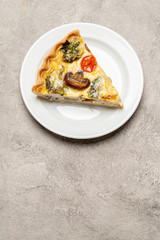 Slice of traditonal homemade spinach chicken quiche tart or pie on plate