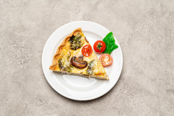 Slice of traditonal homemade spinach chicken quiche tart or pie on plate