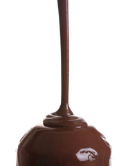 Pouring of melted chocolate on white background