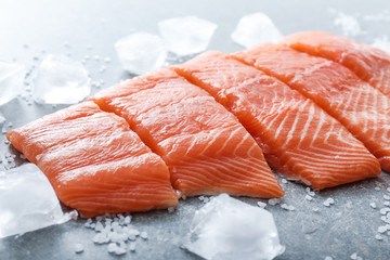 Cut salmon fillet, salt and ice cubes on table