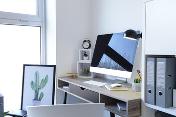 Stylish workplace with modern computer near white wall