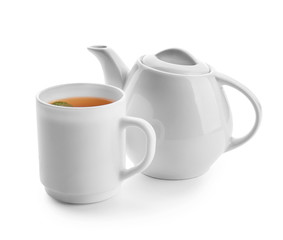 Teapot and cup of hot beverage on white background