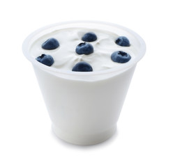 Plastic cup of tasty yogurt with blueberry on white background
