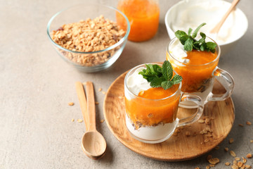 Cups of tasty yogurt with jam on table