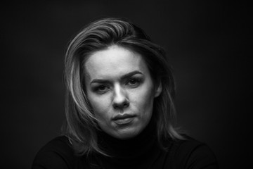 Dramatic black and white portrait of a beautiful woman on a dark background