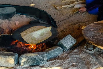 Pita bread cooking on fire in a bedouin dwelling