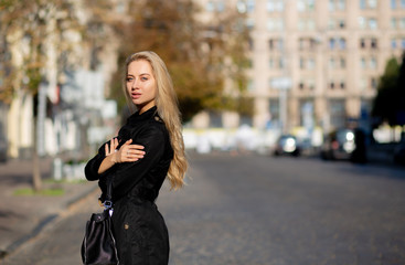 Fototapeta premium Lifestyle shot of glamor blonde woman wearing stylish trench coat and torn jeans. Space for text