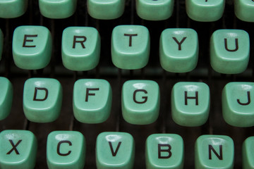 blue keys of an old typewriter with black letters close up