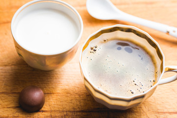 A cup of tasty coffee with milk and some sweets