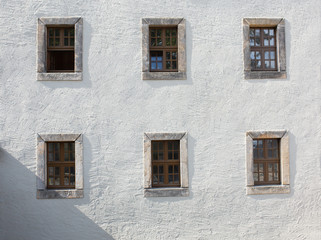 Old wooden windows on the wall outside of building