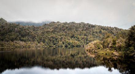 Tasmania, Australia on an Idyllic morning on the Gordon River, we'll take a cruise with great scenery and beautiful reflections in the water near the town of Strahan, on board of a highspeed catamaran