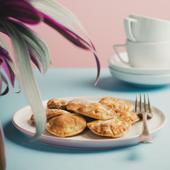 Dutch mini pancakes called poffertjes, sprinkled with powdered sugar. Healthy food concept with copy space. Toned photo.