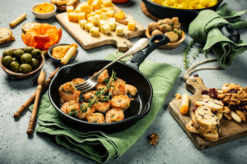 Prawns Shrimps roasted on frying cast iron pan with thyme and garlic. Party food background.