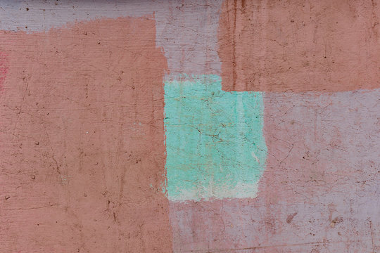 an old painted wall with pealing blue and orange paint