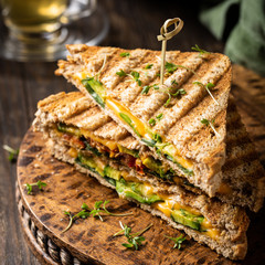 Healthy toasts with avocado, cheddar cheese and tomatoes for breakfast or lunch. Vegetarian sandwiches. Plant-based diet. Whole food concept.