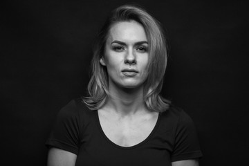 Dramatic black and white portrait of a beautiful woman on a dark background