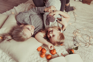 cozy photo session of two beautiful happy sisters in wooden house