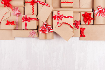 Christmas celebration gifts with red ribbons and bows, blank label on white wood bacground, copy space, top view.