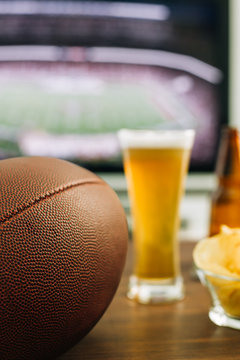 Beer and snacks prepared for watching american football on TV