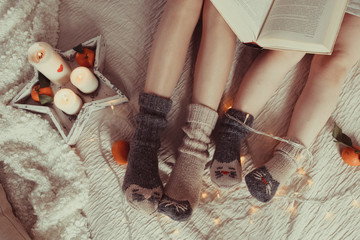 Two pairs of legs in knitted gray socks, photo in Hyugge style,