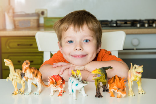 Little boy playing with dinosaurs. Lizard collection