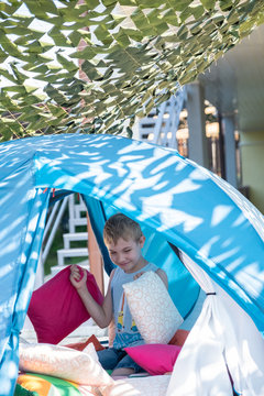 Portrait of cute boy inside tent at backyard